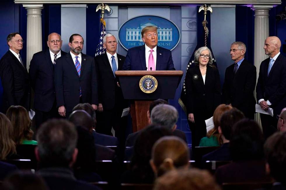 President Donald Trump with members of the president's coronavirus task force speaks during a n ...