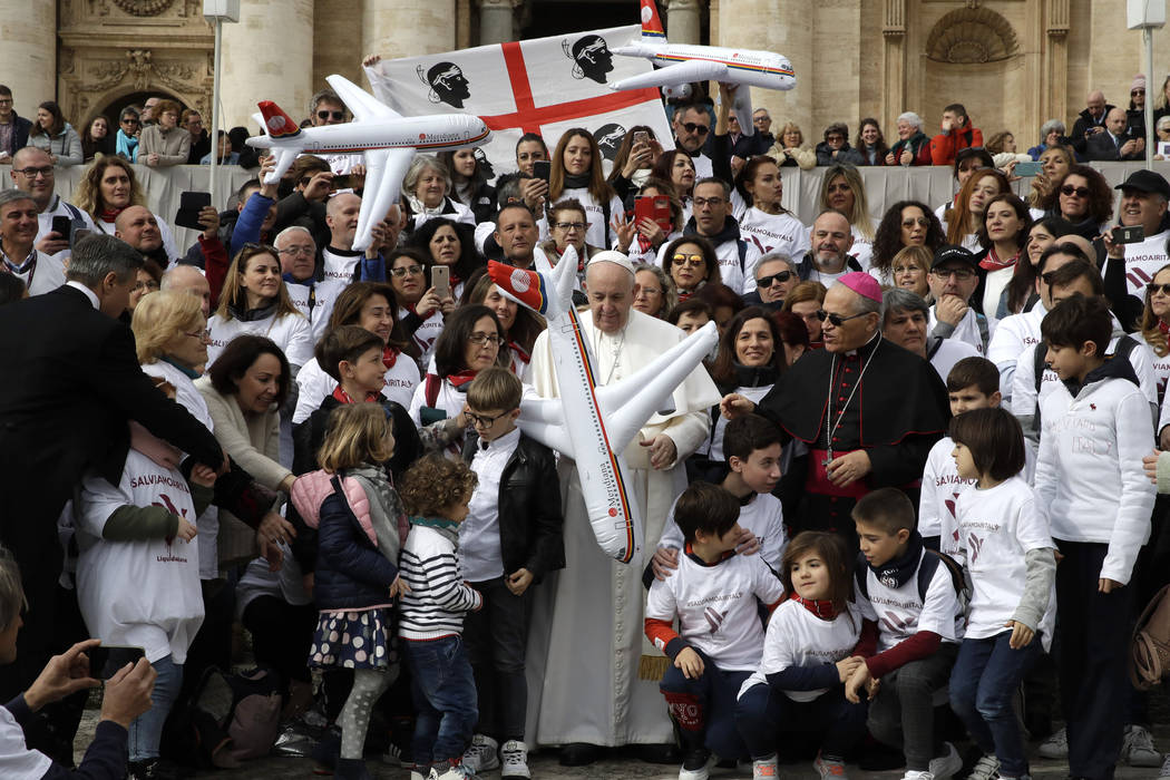 Pope Francis poses for a photo with AirItaly workers and their families in St. Peter's Square a ...