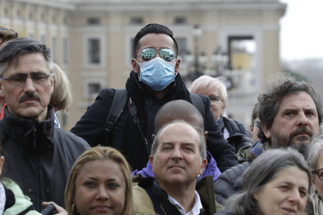 A man wears a face mask in St. Peter's Square at the Vatican during Pope Francis' weekly genera ...