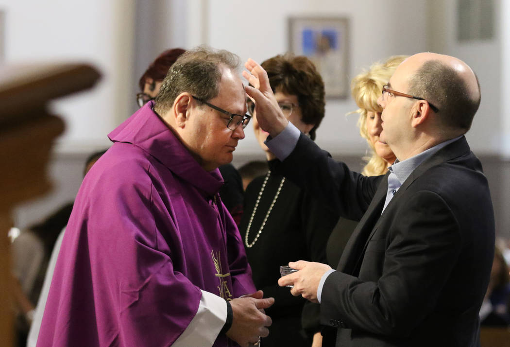 The Rev. Dan Nolan, left, receives ashes from John Keating during Ash Wednesday service at St. ...