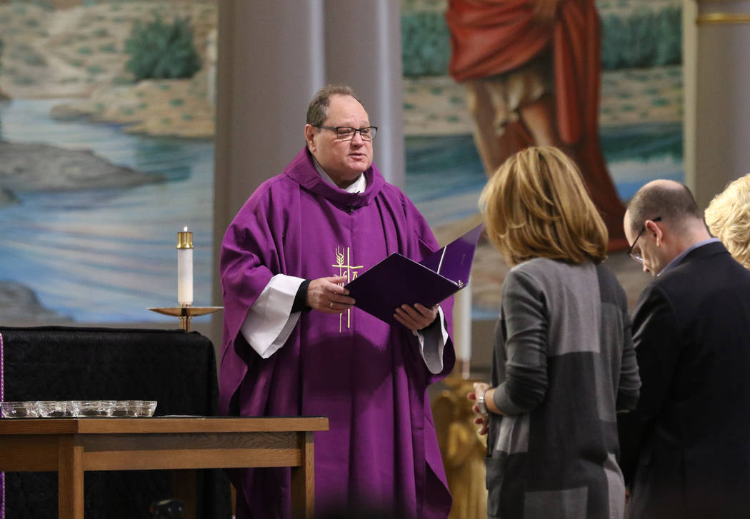 The Rev. Dan Nolan blesses ashes, left, during Ash Wednesday service at St. Viator Catholic Chu ...