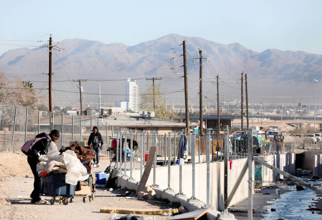 Individuals walk in a homeless community at the intersection of B Street and Owens Avenue in La ...