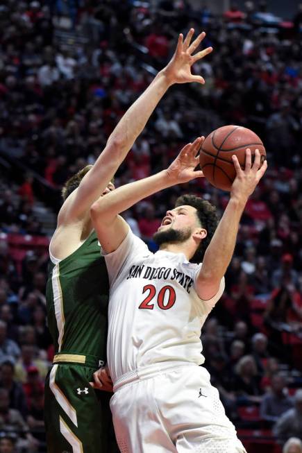 San Diego State guard Jordan Schakel (20) shoots as Colorado State forward Adam Thistlewood def ...