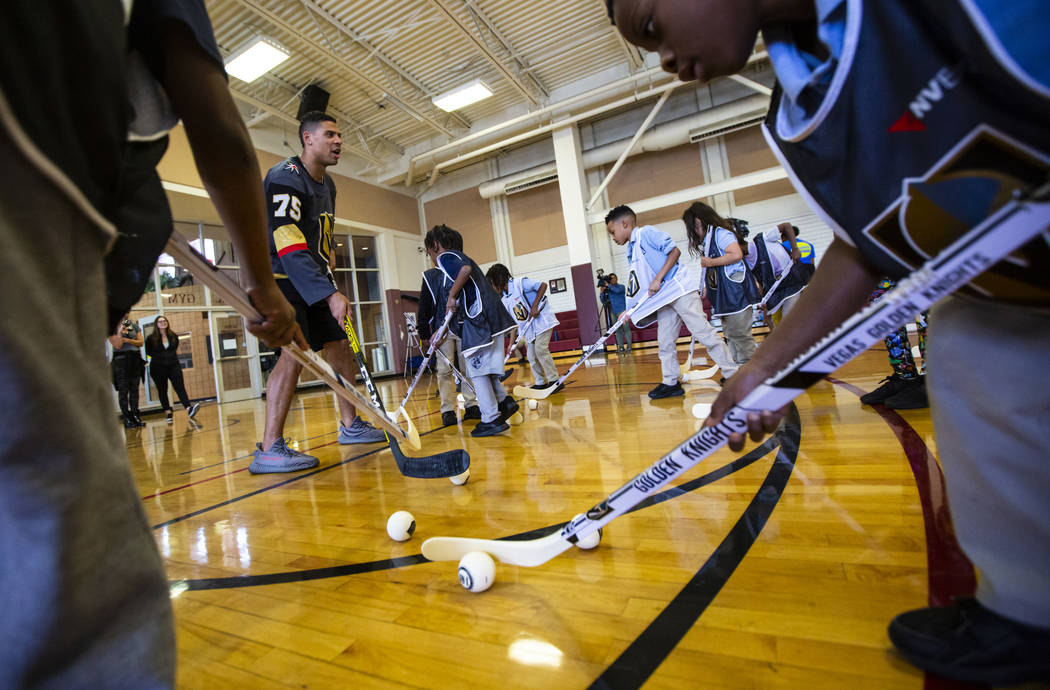 Golden Knights forward Ryan Reaves, left, helps lead a youth street hockey clinic at Doolittle ...