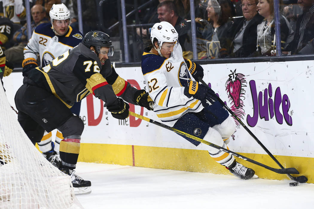 Golden Knights' Gage Quinney (72) battles for the puck against Buffalo Sabres' Brandon Montour ...