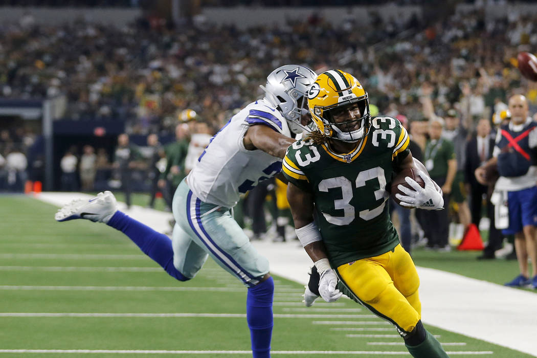 Green Bay Packers' Aaron Jones (33) reaches the end zone for a touchdown in front of Dallas Cow ...