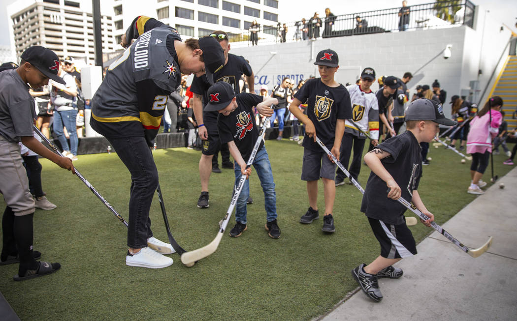 Vegas Golden Knights rookie defenseman Zach Whitecloud, left, plays a little ball hockey with y ...