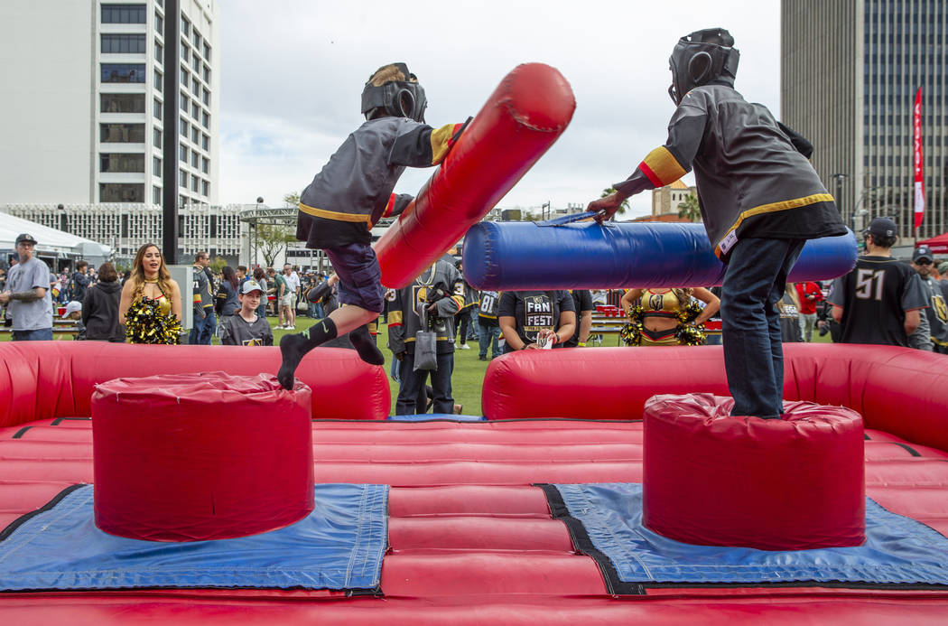 Eric Root, 10, left, is knocked from his perch with a joust from Zi-Ere Davis, 9, as they play ...