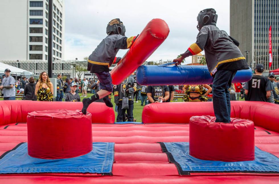 Eric Root, 10, left, is knocked from his perch with a joust from Zi-Ere Davis, 9, as they play ...