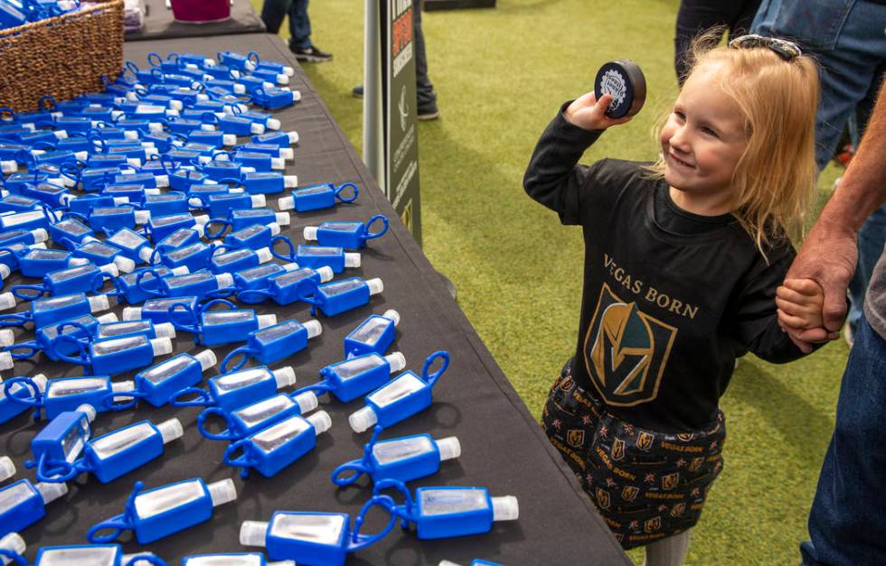 Violet Simpson, 3, shows off her hockey puck beside a table of hand sanitizer during the Vegas ...