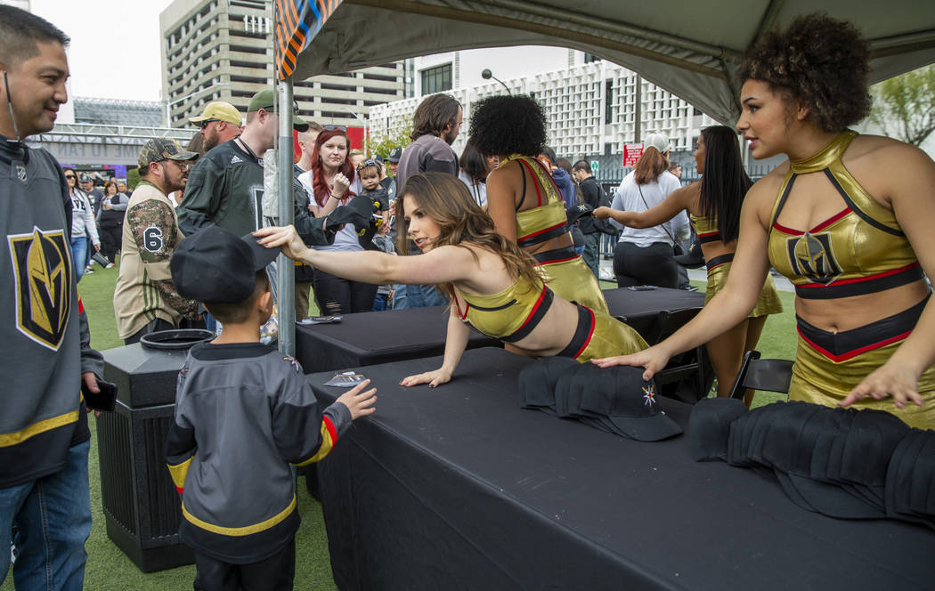 Golden Aces pass out free hats to attendees during the Vegas Golden Knights Fan Fest at the Dow ...