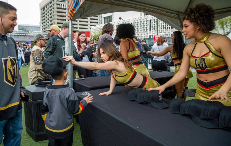 Golden Aces pass out free hats to attendees during the Vegas Golden Knights Fan Fest at the Dow ...