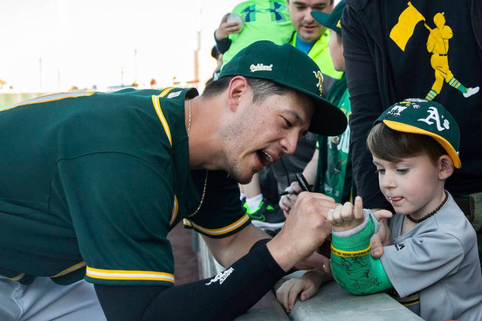 Oakland Athletics catcher Collin Theroux, left, signs the cast of Charleston Kenton, 6, at the ...