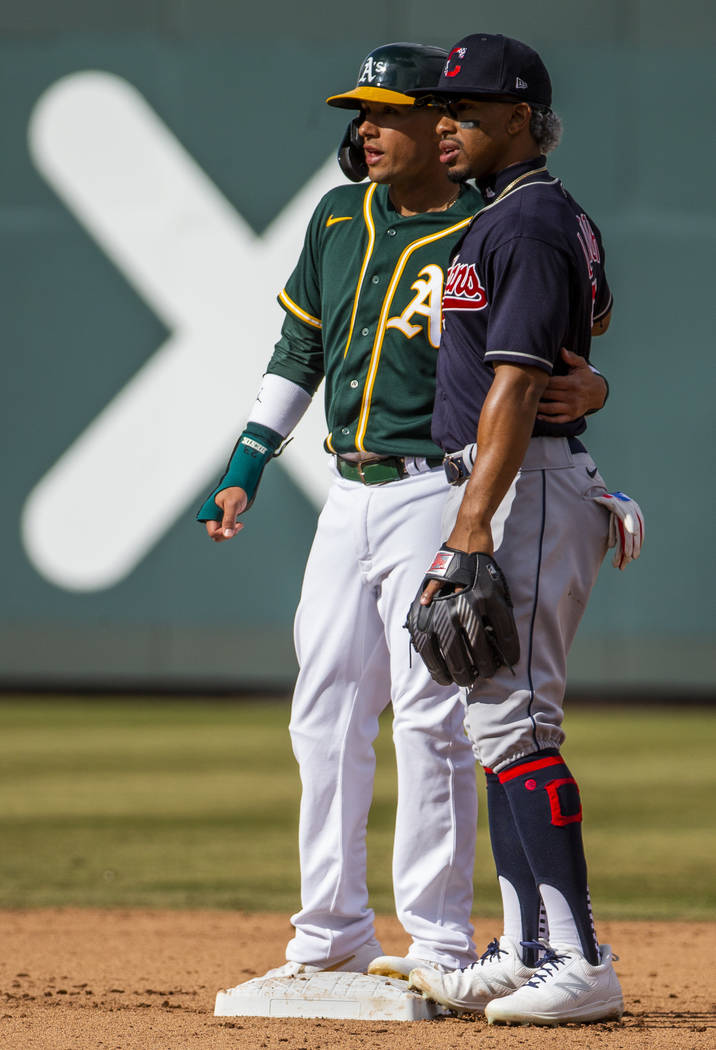 Oakland Athletics runner Ryan Goins (23, left) share a friendly moment with Cleveland Indians i ...