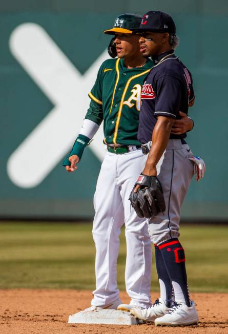 Oakland Athletics runner Ryan Goins (23, left) share a friendly moment with Cleveland Indians i ...