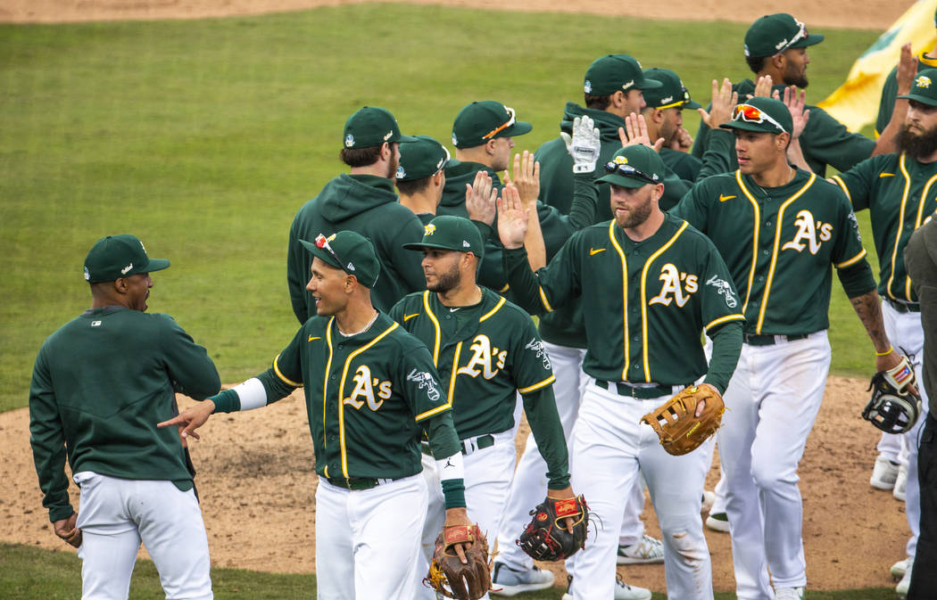 Oakland Athletics players congratulate each other after defeating the Cleveland Indians 8-5 du ...