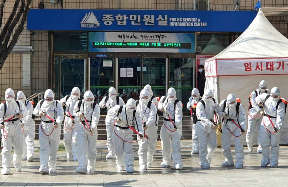 South Korean soldiers wearing protective suits spray disinfectant to prevent the spread of a ne ...