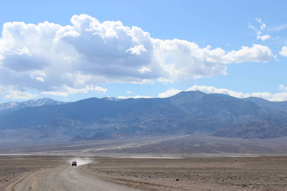 A vehicle travels along West Side Road, located at the base of the Panamint Mountains in Death ...