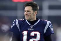 New England Patriots quarterback Tom Brady walks on the field before an NFL wild-card playoff f ...