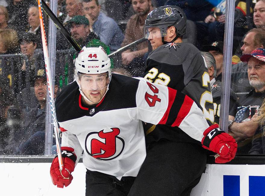 New Jersey Devils left wing Miles Wood (44) hits the boards with Vegas Golden Knights defensema ...