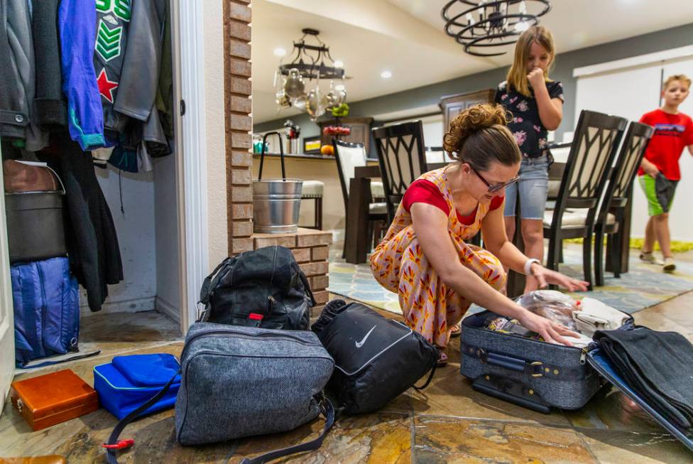 Holly Steed checks on some of the supplies in their 72-hour emergency bags stored in the hall c ...