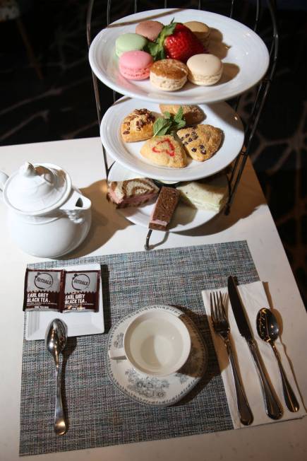 The tea party for two is served with tea, pastries and finger sandwiches with ham, roast beef a ...