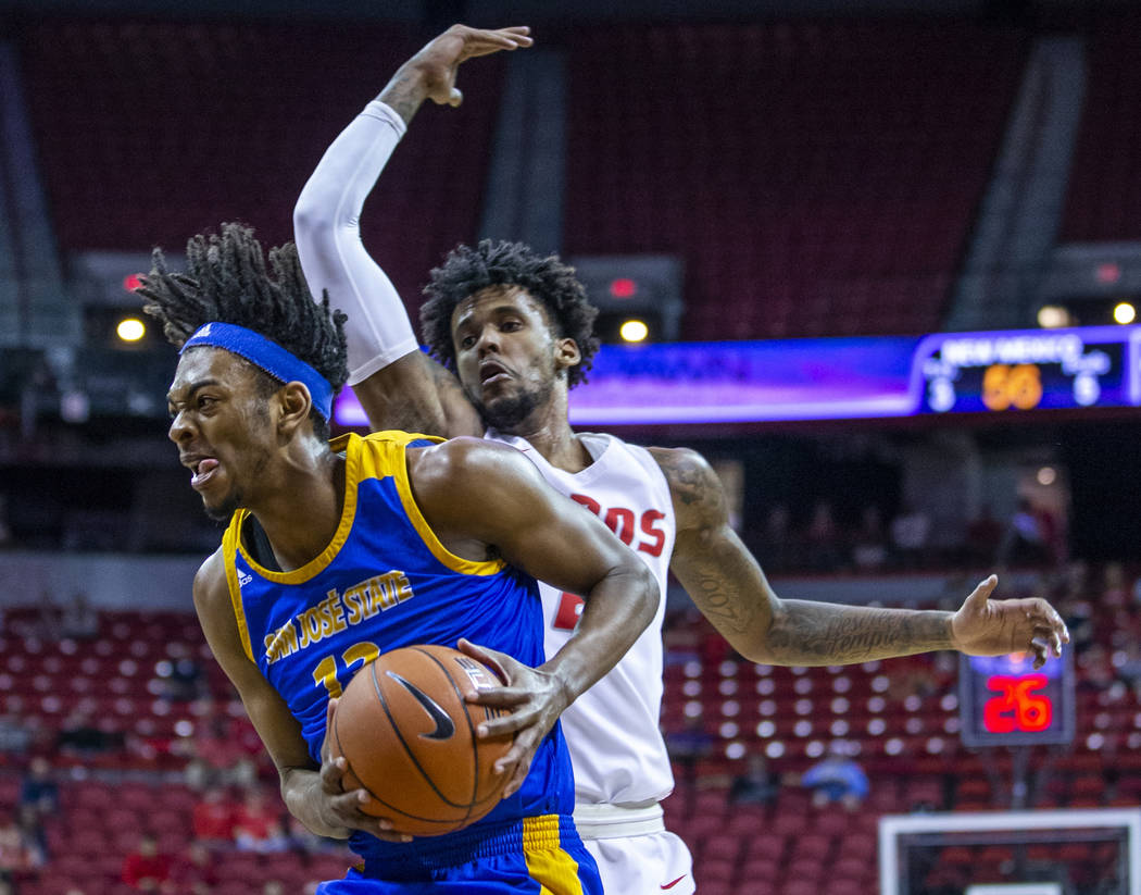 San Jose State Spartans guard Seneca Knight (13, left) sneaks past New Mexico Lobos guard Vanc ...