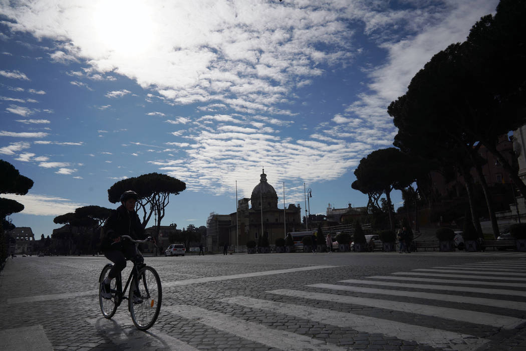 A lone cyclist rides along Via Dei Fori Imperiali (Road of the Imperial Forums) in Rome, Thursd ...