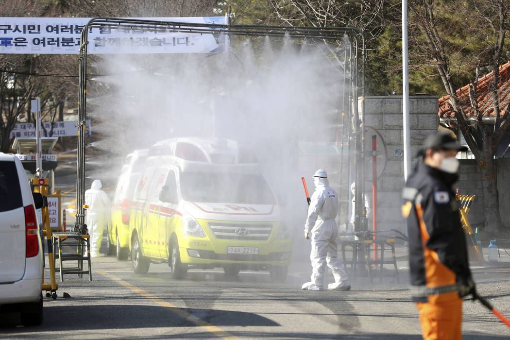 Ambulances are sprayed with disinfectant as a precaution against the new coronavirus in front o ...