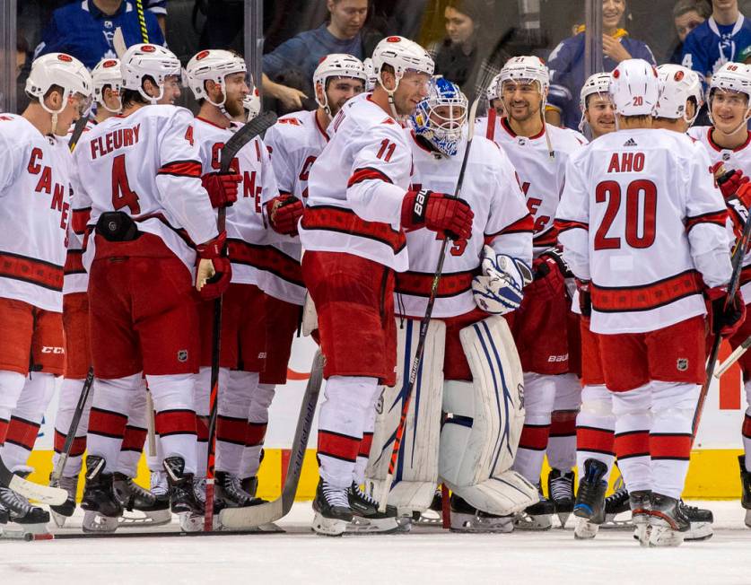 In this Saturday, Feb. 22, 2020 photo, members of the Carolina Hurricanes congratulate emergenc ...