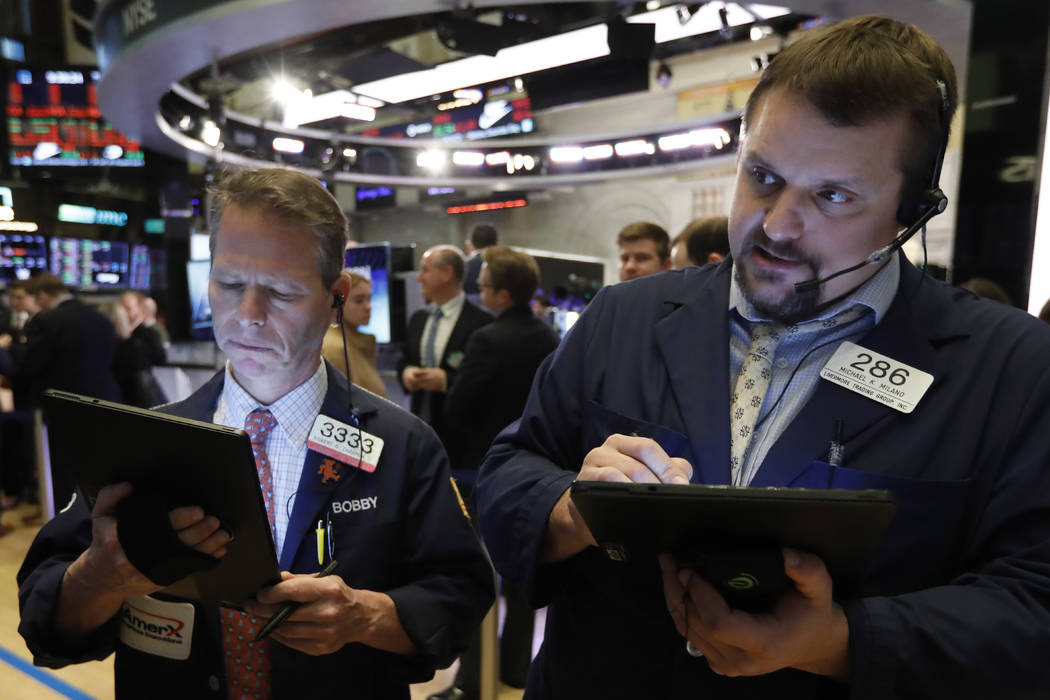 Traders Robert Charmak, left, and Michael Milano work on the floor of the New York Stock Exchan ...