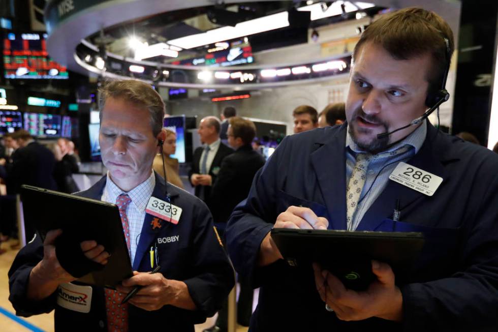 Traders Robert Charmak, left, and Michael Milano work on the floor of the New York Stock Exchan ...