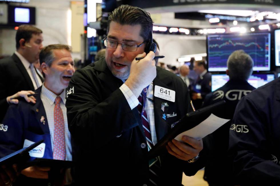 Trader Michael Capolino, center, works on the floor of the New York Stock Exchange, Thursday, M ...
