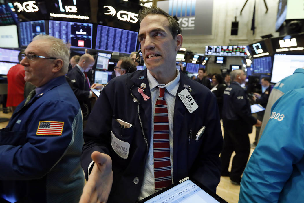 Trader Gregory Rowe, center, works on the floor of the New York Stock Exchange, Thursday, March ...