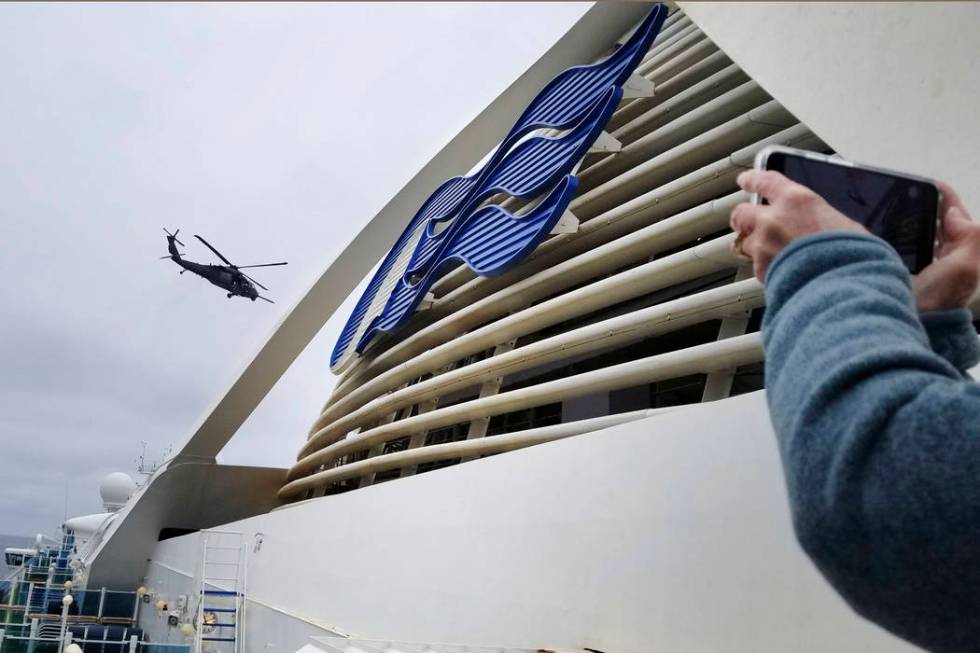 In this photo provided by Michele Smith, a Coast Guard helicopter delivering virus testing kits ...