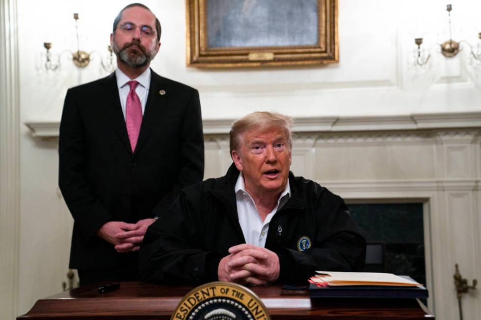 Secretary of Health and Human Services Alex Azar listens as President Donald Trump talks to rep ...