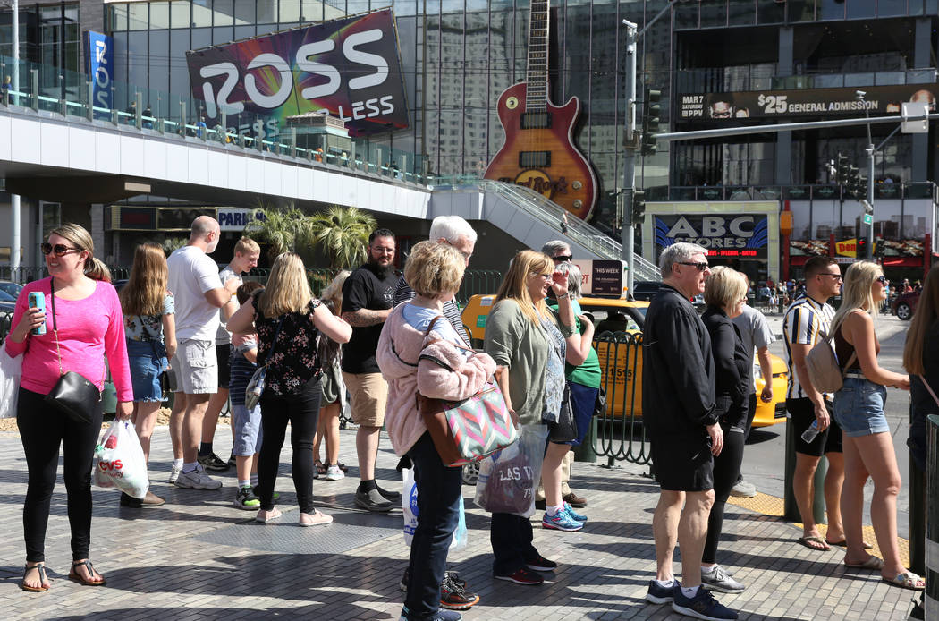 Tourists wait at a traffic lights as they walk along Las Vegas Boulevard on Friday, March 6, 20 ...