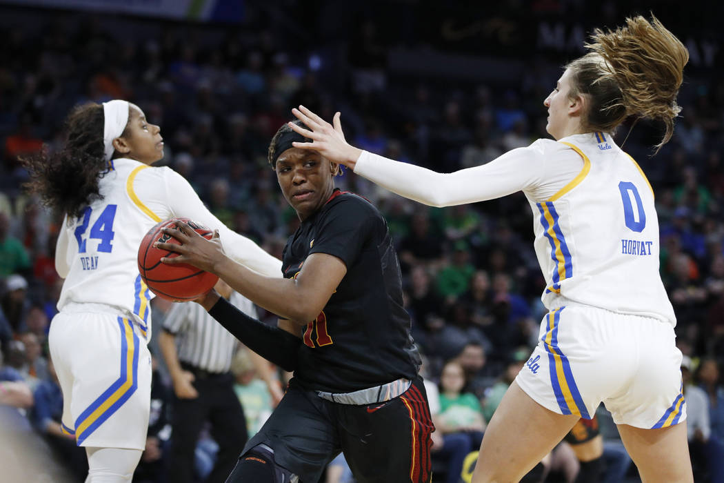 Southern California's Aliyah Jeune (11) passes around UCLA's Chantel Horvat (0) during the seco ...