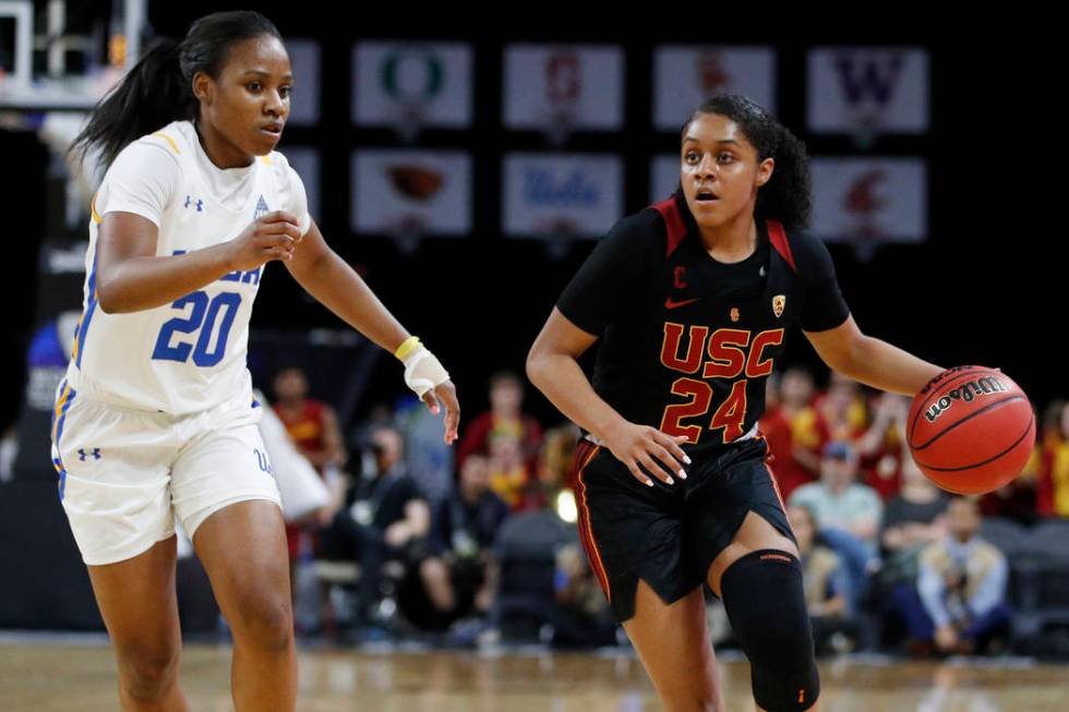 Southern California's Desiree Caldwell (24) drives around UCLA's Charisma Osborne (20) during t ...