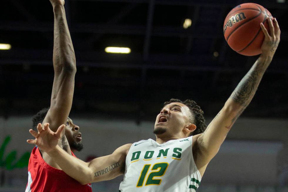 San Francisco Dons guard Trevante Anderson (12) drives past Loyola Marymount Lions forward Park ...