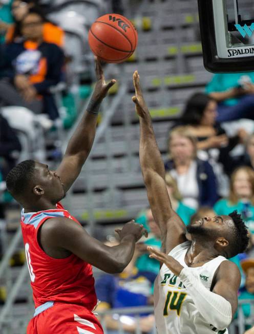 Loyola Marymount Lions guard Eli Scott (0) shoots over San Francisco Dons guard Charles Minlend ...