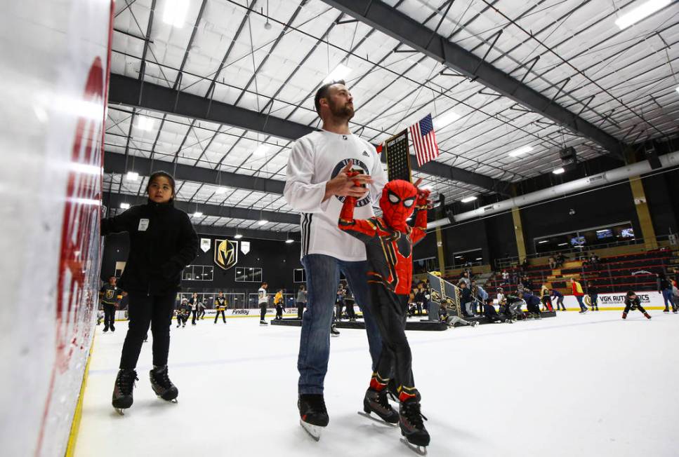 Zach Montgomery, of Las Vegas, helps his son, Michael, 5, skate on the ice at City National Are ...