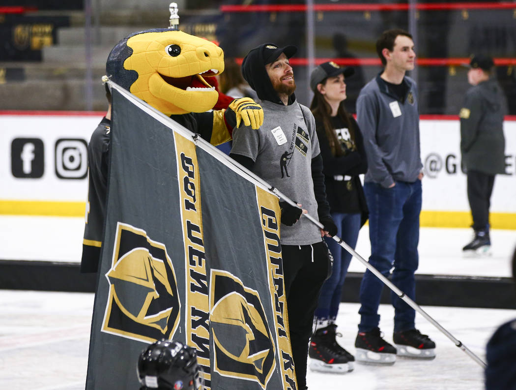 Golden Knights mascot Chance watches an away game against the Winnipeg Jets with fan Matt Helfs ...