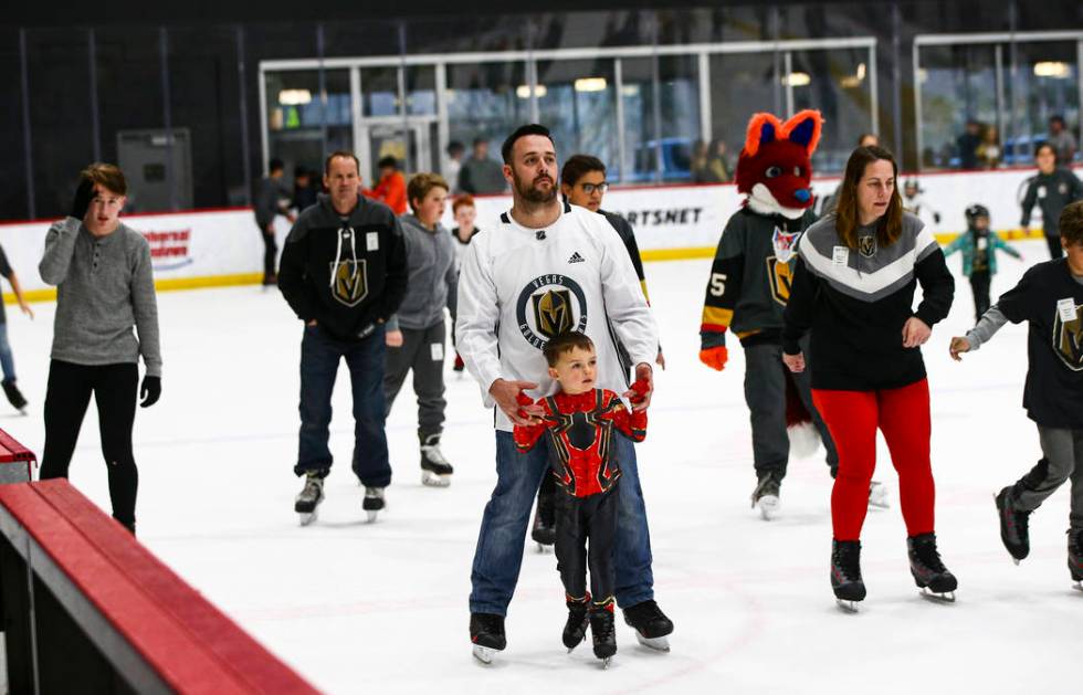 Zach Montgomery, of Las Vegas, helps his son, Michael, 5, skate on the ice at City National Are ...