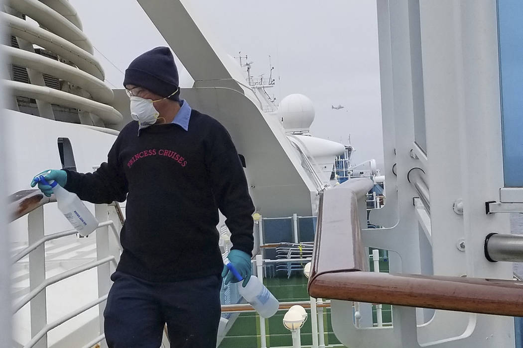 A cruise ship worker cleans a railing on the Grand Princess Thursday, March 5, 2020, off the Ca ...
