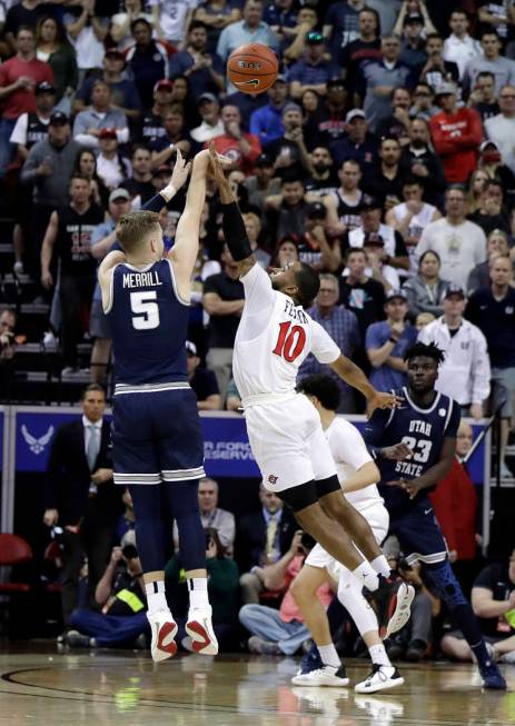 Utah State's Sam Merrill (5) sinks a 3-point shot as San Diego State's KJ Feagin defends during ...