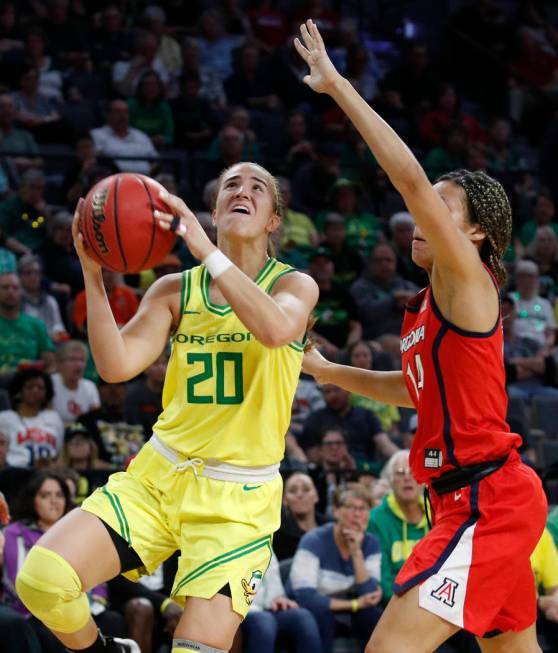 Oregon's Sabrina Ionescu (20) shoots around Arizona's Sam Thomas (14) during the second half of ...