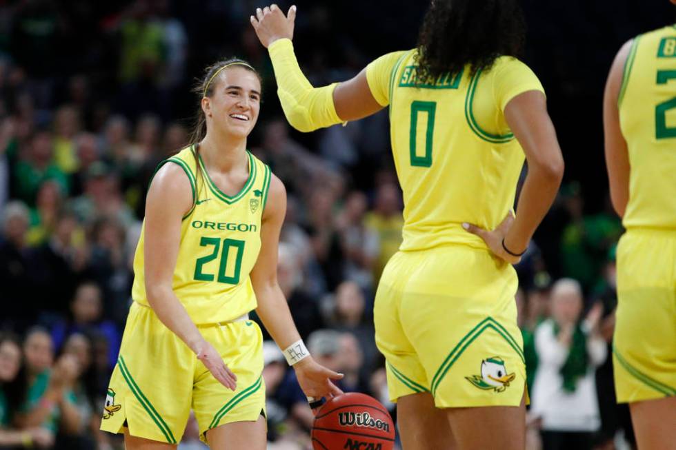 Oregon's Sabrina Ionescu (20) and Satou Sabally (0) celebrate after defeating Arizona in an NCA ...