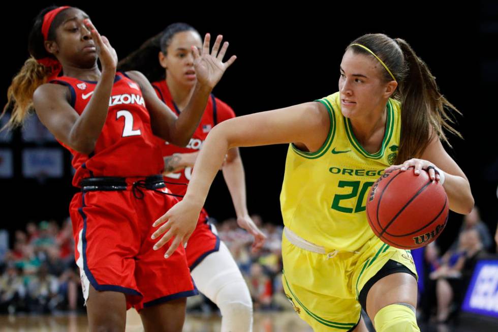 Oregon's Sabrina Ionescu (20) drives around Arizona's Aarion McDonald (2) during the second hal ...