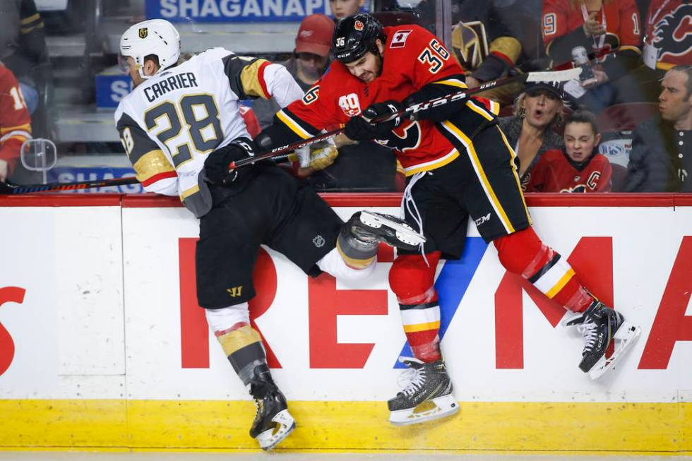 Vegas Golden Knights' William Carrier, left, is checked by Calgary Flames' Zac Rinaldo during t ...